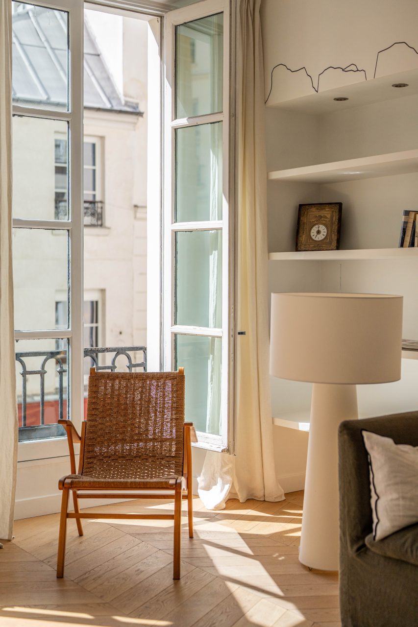 Fauteuil près d’une grande fenêtre dans un salon lumineux à Paris 1