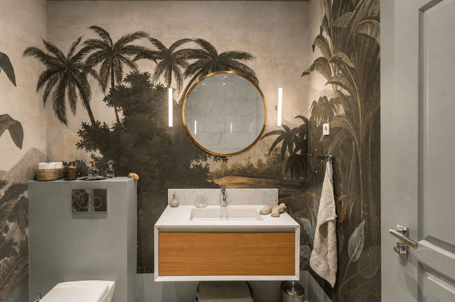 1 790 000 € - Paris 1er • Vendôme / Saint-Honoré • 114 m² avec terrasse Salle de bain avec papier peint panoramique, miroir laiton et meuble vasque contemporain dans un appartement à Paris 1