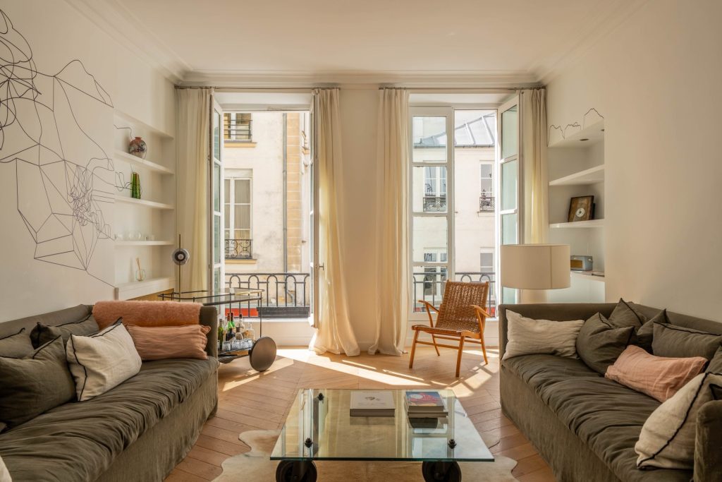 1 995 000 € - Paris 1er - Vendôme / Saint-Honoré - 114 m² with terrace Salon lumineux avec parquet en point de Hongrie, grandes fenêtres et mobilier design dans un appartement à Paris 1
